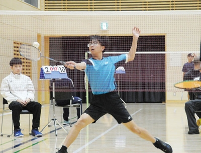 写真:懸命に腕を伸ばしてシャトルを打ち返す男子選手