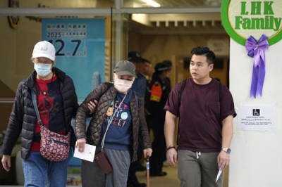 写真:立法会選挙の投票を終え、火災が起きた高層住宅群近くの投票所を出る有権者ら=7日、香港