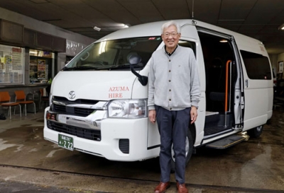 写真：送迎車両と「東ハイヤー」の松本年弘社長＝せたな町