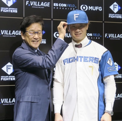 写真:入団記者会見を終え、撮影に応じる日本ハム・西川。左は栗山CBO=8日、エスコンフィールド北海道