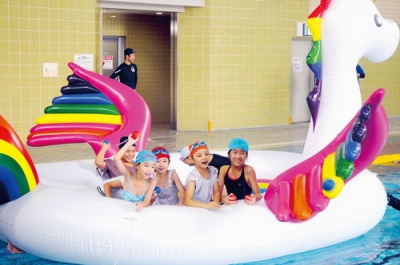 写真:巨大ユニコーン型フロートで遊ぶ子どもたち