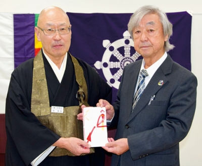 写真：長谷川会長（右）に善意を手渡した室蘭佛教会の西会長
