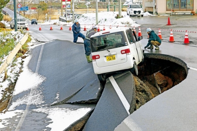 写真:強い地震があった青森県東北町の陥没した道路で作業する人たち=9日午後0時8分