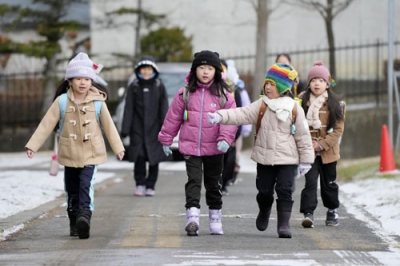 写真:学校が再開し、登校する青森県八戸市立江南小の児童たち=10日午前7時34分