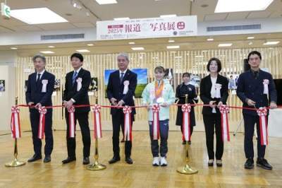 写真:「2025年報道写真展」のオープニングセレモニーで、テープカットする体操女子の杉原愛子選手(中央右)=10日午前、東京都中央区の日本橋三越本店