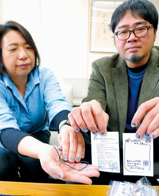 写真:寄贈したミサンガを手にするメンバー
