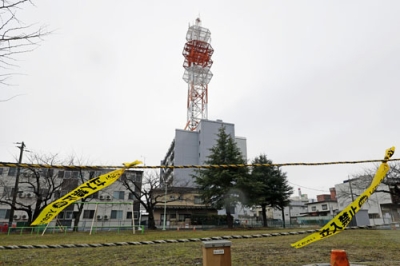 写真:一部に損傷が見つかった「NTT青森八戸ビル」の屋上に設置された鉄塔。周辺が規制された=11日午前、青森県八戸市