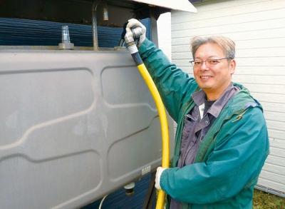 写真：迅速丁寧に灯油を給油する中山代表
