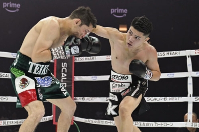 写真：プロ３戦目となったボクシング・スーパーフライ級１０回戦で、カルロス・クアドラス（左）を攻める坪井智也＝１１月、トヨタアリーナ東京