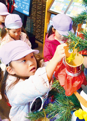 写真：クリスマスツリーを飾り付ける園児たち
