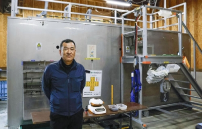 写真：「減容化装置」の前に立つ、ＢＯＤ商会代表の高原正樹さん＝１１月、福島町