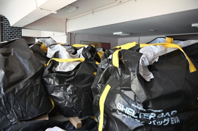 写真：建設中の最終処分場に隣接する旧保育所に仮置きされているダイオキシン廃棄物が入ったフレコンバッグ＝７月、大阪府豊能町