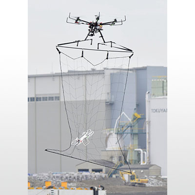 写真:2016年1月、テロ対処訓練で小型のドローンを捕獲する警視庁の「迎撃ドローン」(上)=東京都江東区