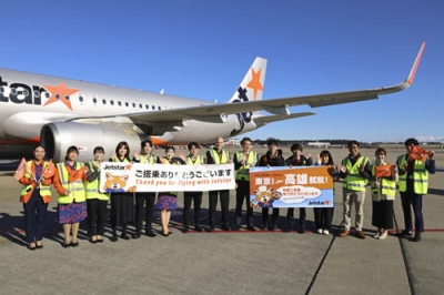 写真：駐機場で記念写真に納まるジェットスター・ジャパンの関係者ら＝１８日午前、成田空港