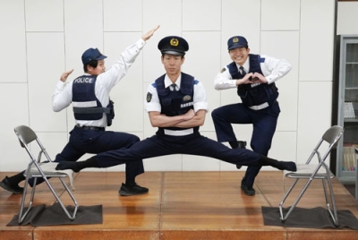 写真：格闘漫画「刃牙」シリーズの有名シーンを再現したポーズを決める長崎県警南島原署の青栁匡彦巡査部長（中央）ら＝南島原署