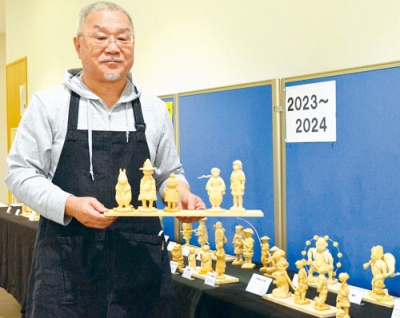 写真：展示作品を手に持つ遠山さん