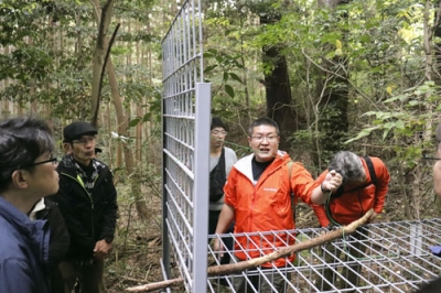 写真：狩猟に使う箱わなの仕組みを説明する「ハンターバンク」のスタッフ＝２０２５年１１月、神奈川県小田原市