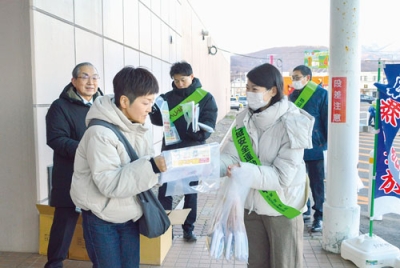 写真：来店者にチラシを配布して特殊詐欺に注意を呼びかける啓発参加者ら