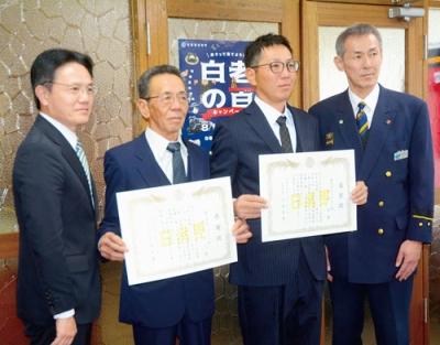 写真：感謝状を受けた秀己さん（中央左）と表彰状を授与された忍さん（同右）