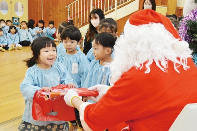 写真：サンタからクリスマスプレゼントをもらう園児たち