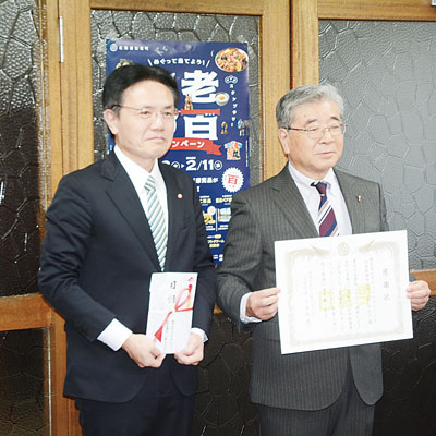 写真：目録を手渡した高畠工園長（右）と大塩町長