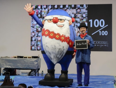 写真：大阪・関西万博の会場で制作した「みらいサンタ」と谷口智則さん＝９月、大阪市此花区の夢洲