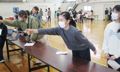 写真：割り箸鉄砲とゴムを使った射的を楽しむ児童たち（提供写真）