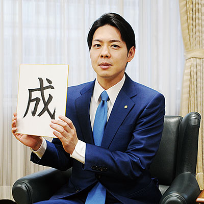 写真：「成」の字が書かれた色紙を手にする鈴木知事