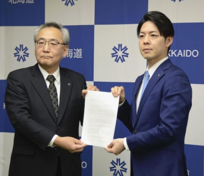 写真：北海道電力の斎藤晋社長（左）に要請文を手渡す鈴木直道知事＝２４日午後、札幌市