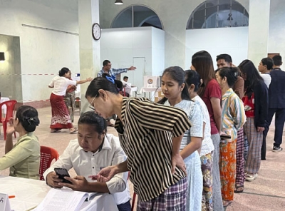 写真：２８日、ミャンマー最大都市ヤンゴンの投票所に並ぶ有権者ら（共同）