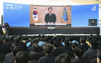 写真：２９日、韓国の務安国際空港で開かれた追悼式典で映し出された李在明大統領の映像メッセージ（共同）