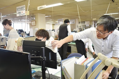 写真：仕事納めでデスク回りを丁寧に清掃する職員＝３０日、伊達市役所