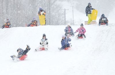 写真:そり滑りを楽しむ両市の子どもたち