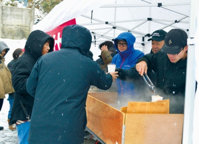 写真:鬼汁を受け取る観光客