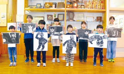 写真:掲載している版画を披露する児童たち