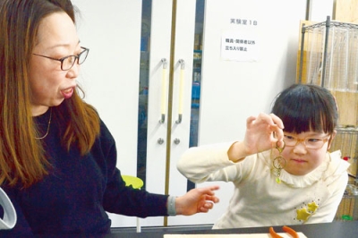 写真：ボトルキャップを材料にキーホルダーを作る親子