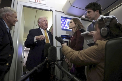 写真：４日、米大統領専用機内で記者団の取材に応じるトランプ大統領（ロイター＝共同）