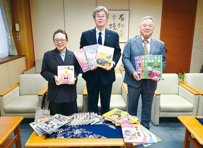 写真：伊達市立図書館に児童書を届けた野口社長（左）と秋葉常務取締役（右）（提供写真）