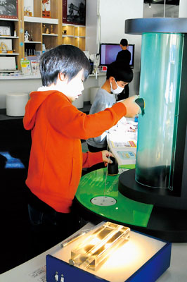 写真:実験などを楽しむ小学生=DENZAI環境科学館