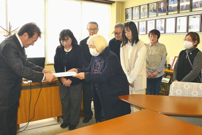 写真：千田議長（左）に公開質問状を手渡す有志の会のメンバー