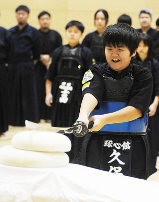 写真：鏡餅に刀を振り下ろす久保さん