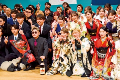 写真：舞台の上で仲間と記念写真に収まる参加者ら＝室ガス文化センター