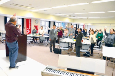 写真:「頑張ろう」のかけ声で結束を固める関係者