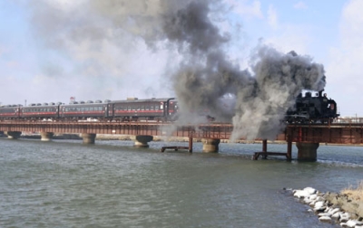 写真：釧路川の鉄橋を渡る観光列車「ＳＬ冬の湿原号」＝１４日午前、釧路市