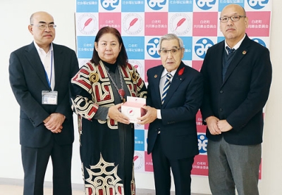 写真：寄付金を手渡す村木本部長（左から２番目）