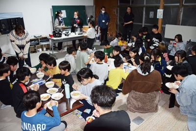 写真：一緒に作った夕食を味わう子どもたち