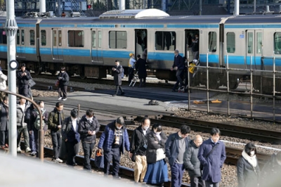 写真：新橋―浜松町間で停車したＪＲ京浜東北線の車両から降りて線路を歩く乗客＝１６日午前９時５５分、東京都港区