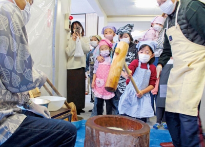 写真：笑顔で元気いっぱいに餅をつく子どもたち