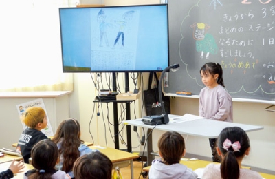 写真：教室で冬休みの思い出を発表する児童