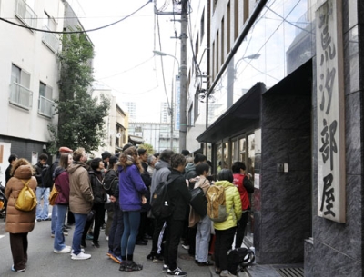 写真：荒汐部屋の朝稽古を見学する訪日客ら＝２０２５年１２月、東京都中央区